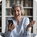 Mujer sonriendo y disfrutando de contenido en su teléfono móvil  