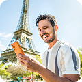 Un joven en París con la Torre Eiffel al fondo consultando su teléfono gracias a las tarifas con Roaming de Lowi  
