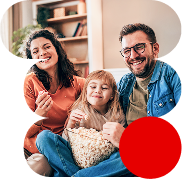 Una familia disfrutando de su nueva tarifa de fibra, móvil y Disney+ mientras comen palomitas 