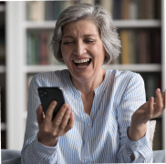 Mujer sonriendo y disfrutando de contenido en su teléfono móvil  