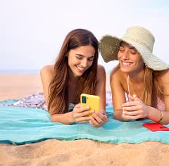 Mujer sonriendo y disfrutando de contenido en su teléfono móvil