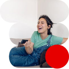 Una chica riendo mientras está con su mando a distancia